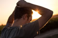 young man pulling his hair facing the sun